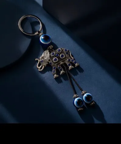 Cute elephant keychain with evil eye beads. It's made of metal with blue gem accents. Attaches to a standard key ring. - Image 3