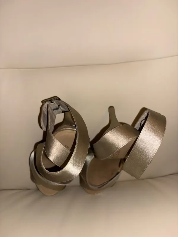 Arezzo brand sandals stand out for their sophisticated gold tone and crisscrossing straps. Elegant style with a high heel. Adjustable ankle strap. Metallic gold color. - Image 4