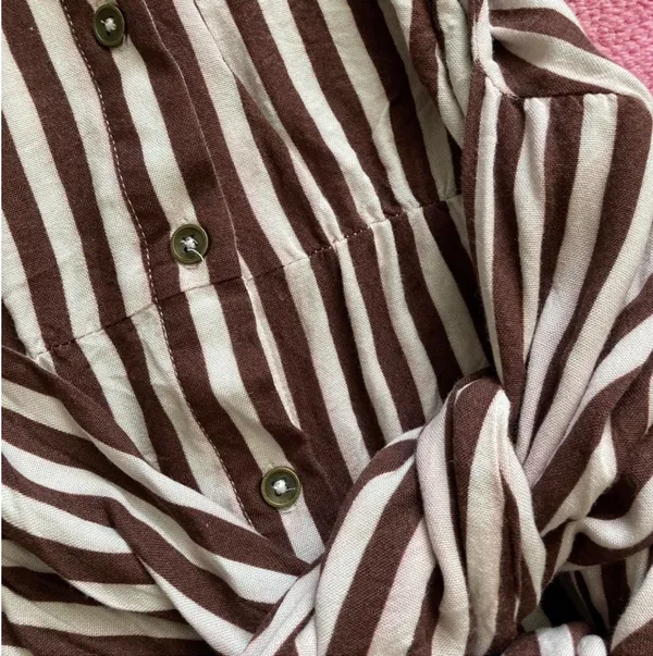 Jen’s Pirate Booty Amaya brown and white striped mini dress in size XS. This has only been worn once and has no rips, tears, or stains. Some color transfer between stripes from washing but it’s not really noticeable as seen in photos. The waist can be tied in front with excess or in back (I like to go around twice and tie in back). Ultra soft and flowy material, love this dress and only selling as it just isn’t quite my style. Measures 30” long, 17” across chest, 14” across at waist, 22” long sleeve (from shoulder seam). - Image 3