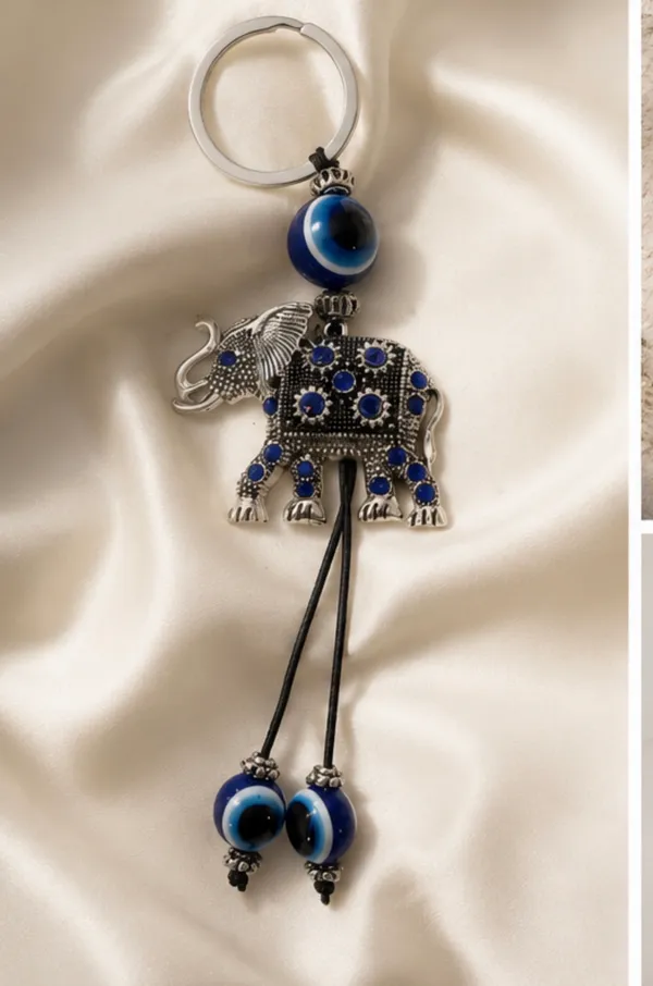 Cute elephant keychain with evil eye beads. It's made of metal with blue gem accents. Attaches to a standard key ring. - Image 4