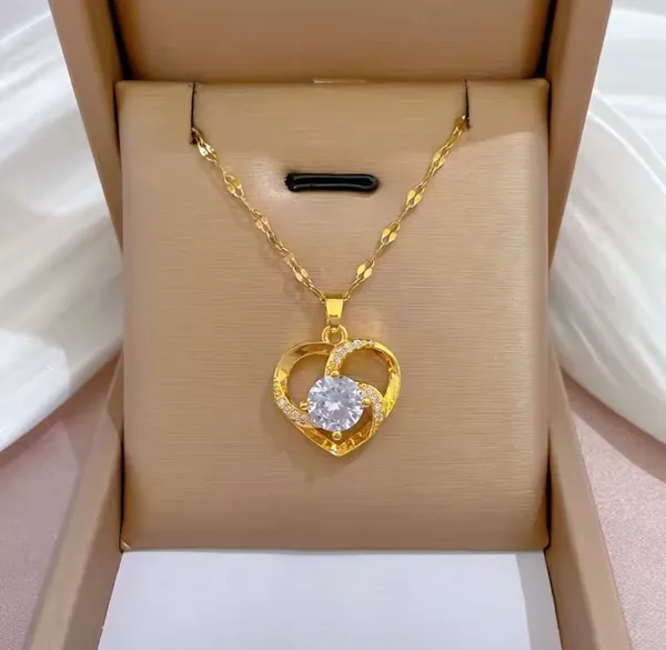 This elegant heart necklace is made from 18k gold-plated stainless steel and features a large central cubic zirconia stone surrounded by smaller crystal accents. - Image 2