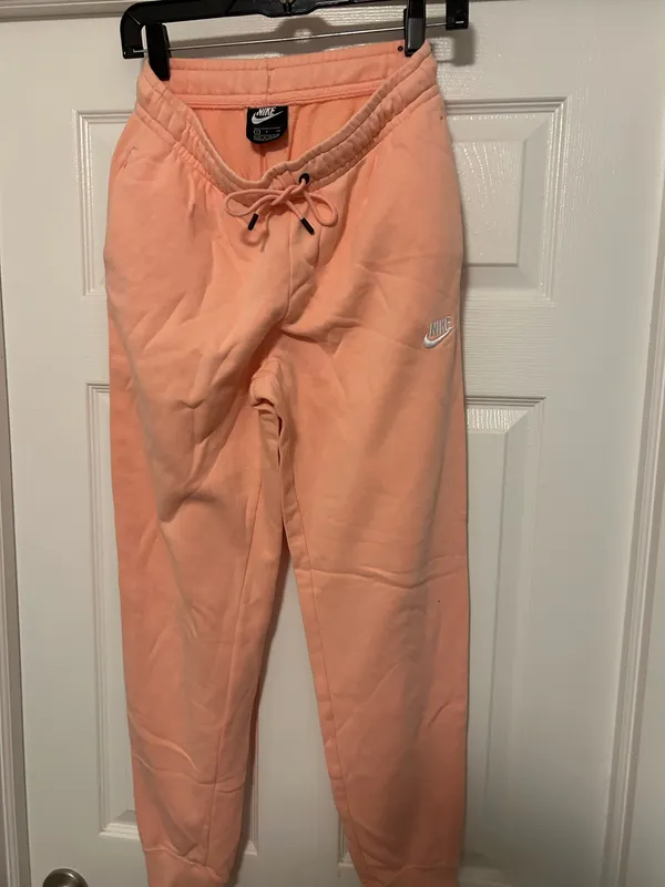 NIKE size small Soft fleece joggers in a warm peach-coral shade. Elastic waistband with adjustable drawstring. Tapered legs with cuffed ankles. Embroidered Nike logo at hip. Cozy everyday women small brand new - Image 6
