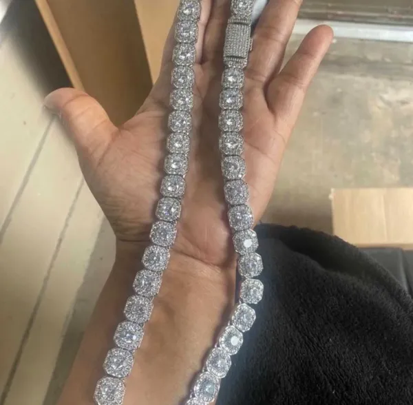 Make a statement with this iced-out cushion-cut tennis necklace, featuring rows of brilliant, sparkling stones set in a classic tennis-chain design. The cushion-shaped stones give it a bold, clean look while creating plenty of shine from every angle. ✨ Features: * 💎 Cushion-cut stone design * ❄️ Fully iced-out, high-shine appearance * 🔗 Classic tennis necklace style * ✨ Eye-catching sparkle in natural and flash lighting * 👑 Bold luxury-inspired look * 🖤 Great for everyday wear, going out, parties, photoshoots, or stacking with other chains * 🎁 Makes a great gift for anyone who loves statement jewelry - Image 4