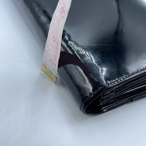 Black faux patent leather clutch with wave design on front. - Image 9