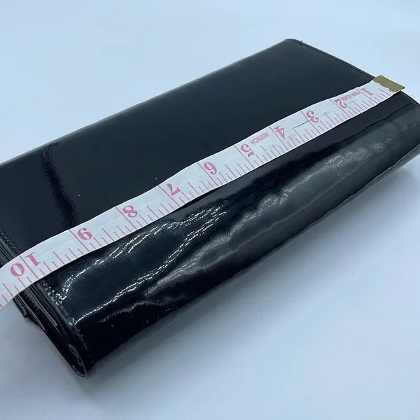 Black faux patent leather clutch with wave design on front. - Image 7