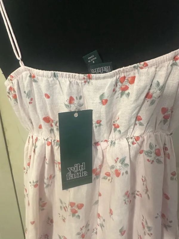 New with tags Wild Fable mini dress is a size small. This pink garment has a red strawberry print throughout. It is made of a linen-blend fabric and has adjustable spaghetti straps, a ruffled V-neckline with a tie-front detail, and a tiered skirt. - Image 3