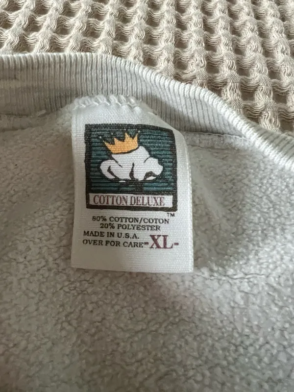 Comfortable light gray crewneck sweatshirt with a small embroidered crest on the chest. Soft, durable fabric for everyday wear. Ribbed cuffs and hem provide a secure fit. Neutral light gray pairs easily with casual outfits. - Image 3