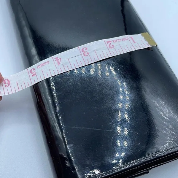 Black faux patent leather clutch with wave design on front. - Image 8