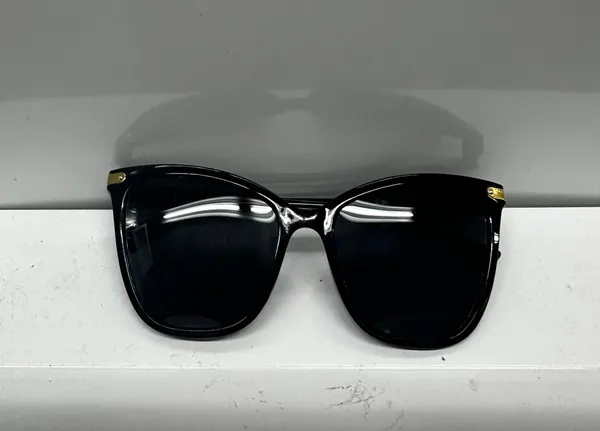 Stylish black sunglasses with gold accents. - Image 2