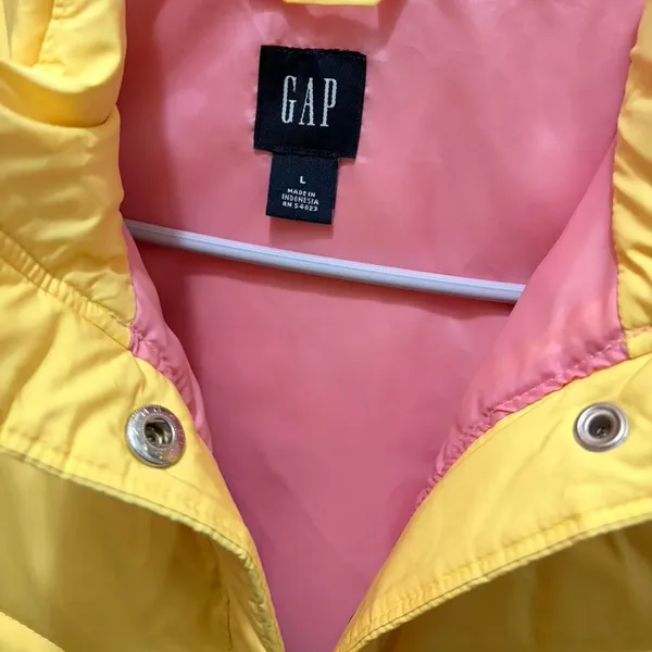 bright yellow Gap puffer vest with a contrasting pink lining and snap button closures - Image 2