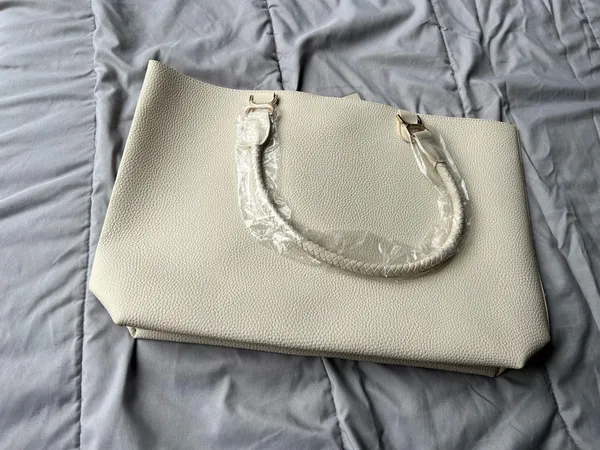 Ulta Beauty Tote Bag – Cream (New in packaging) Add a clean, elegant touch to your outfits with this beautiful tote! It comes in a super versatile cream/ivory shade, featuring a textured faux-leather finish and unique braided handles that give it a chic look. - Image 3