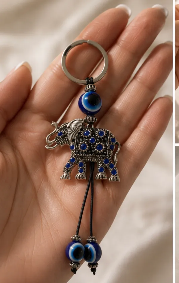 Cute elephant keychain with evil eye beads. It's made of metal with blue gem accents. Attaches to a standard key ring. - Image 2