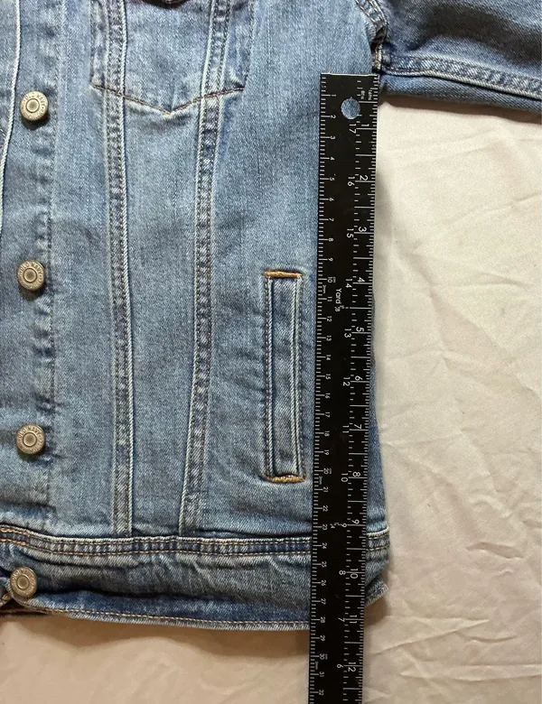 The Old Navy Blue Denim Trucker Jacket is a classic button-up long sleeve jacket in a traditional trucker style. Made from denim, manufactured in Bangladesh.Pit to pit: 18 in. Length: 20 in. Pre-owned with no visible wear. Buttons are all intact and the jacket lays flat with no distortion - Image 8