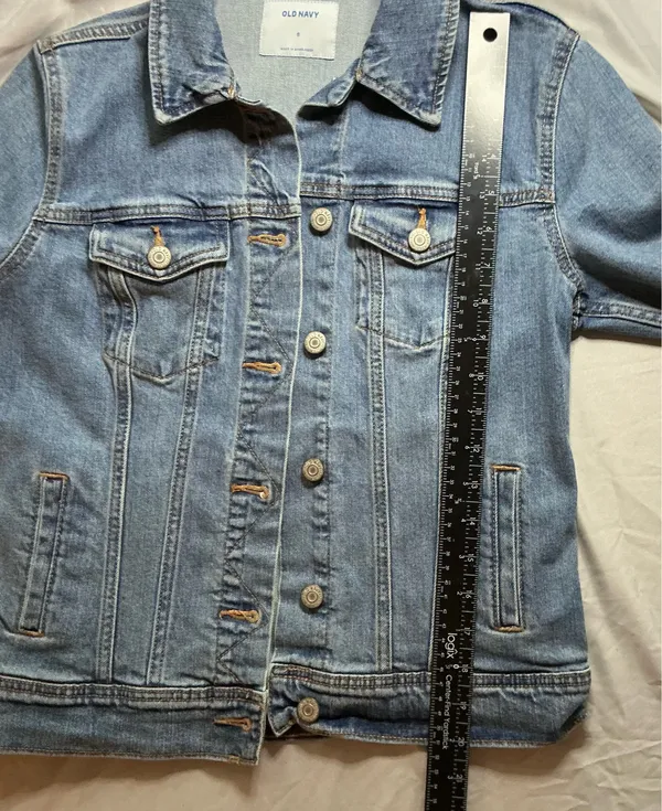 The Old Navy Blue Denim Trucker Jacket is a classic button-up long sleeve jacket in a traditional trucker style. Made from denim, manufactured in Bangladesh.Pit to pit: 18 in. Length: 20 in. Pre-owned with no visible wear. Buttons are all intact and the jacket lays flat with no distortion - Image 5