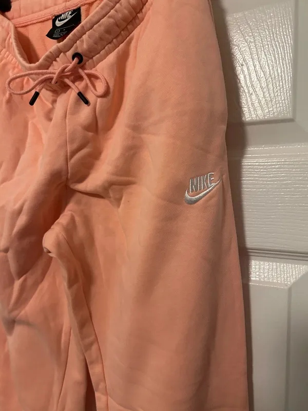NIKE size small Soft fleece joggers in a warm peach-coral shade. Elastic waistband with adjustable drawstring. Tapered legs with cuffed ankles. Embroidered Nike logo at hip. Cozy everyday women small brand new - Image 7