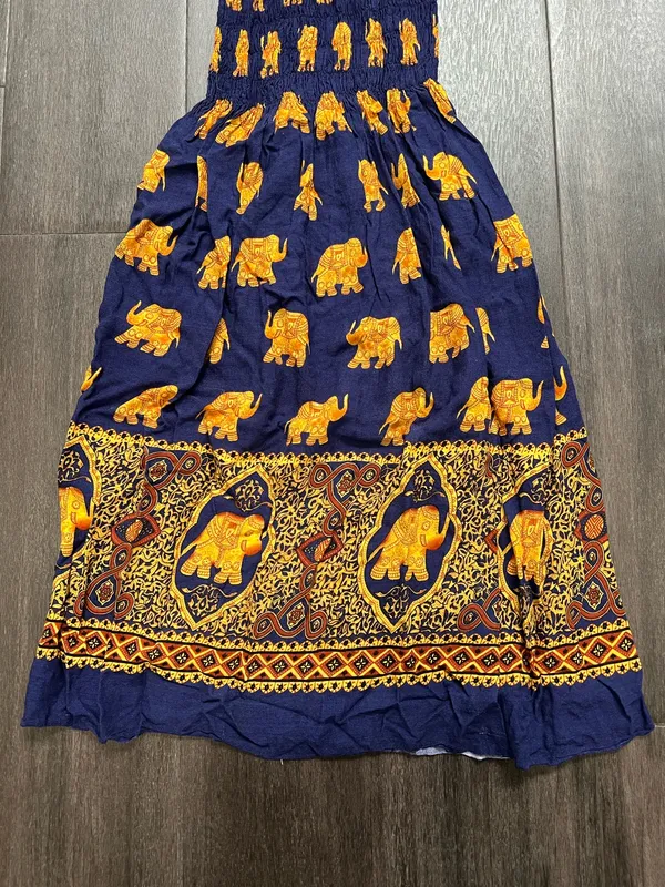 Flowy halter maxi dress with a smocked bodice. Navy base with repeating golden elephant motif. Decorative border print at hem. Lightweight and breezy. Adjustable tie straps. - Image 3