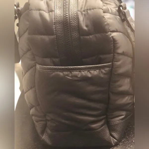 Cynthia Rowley Anthropologie’s Quilted Puffer Travel Bag is a stylish and functional accessory designed for travel enthusiasts. Crafted from high-quality materials, this bag features a quilted exterior for added texture and durability. Its spacious interior provides ample room for belongings, while the thoughtful design includes convenient pockets for organization. The soft puffer style adds a chic touch, making it suitable for various occasions, whether heading to the gym or embarking on a weekend getaway. With comfortable straps for easy carrying, this travel bag combines practicality with fashionable flair. - Image 4