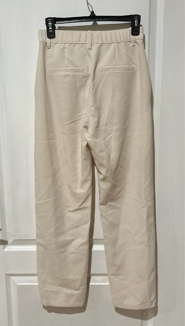 Abercrombie & Fitch high-waisted trousers. The design features a classic straight-leg silhouette with subtle front pleating, diagonal side pockets, and a button-and-zip fly closure in a cream or "oyster" shade. - Image 2