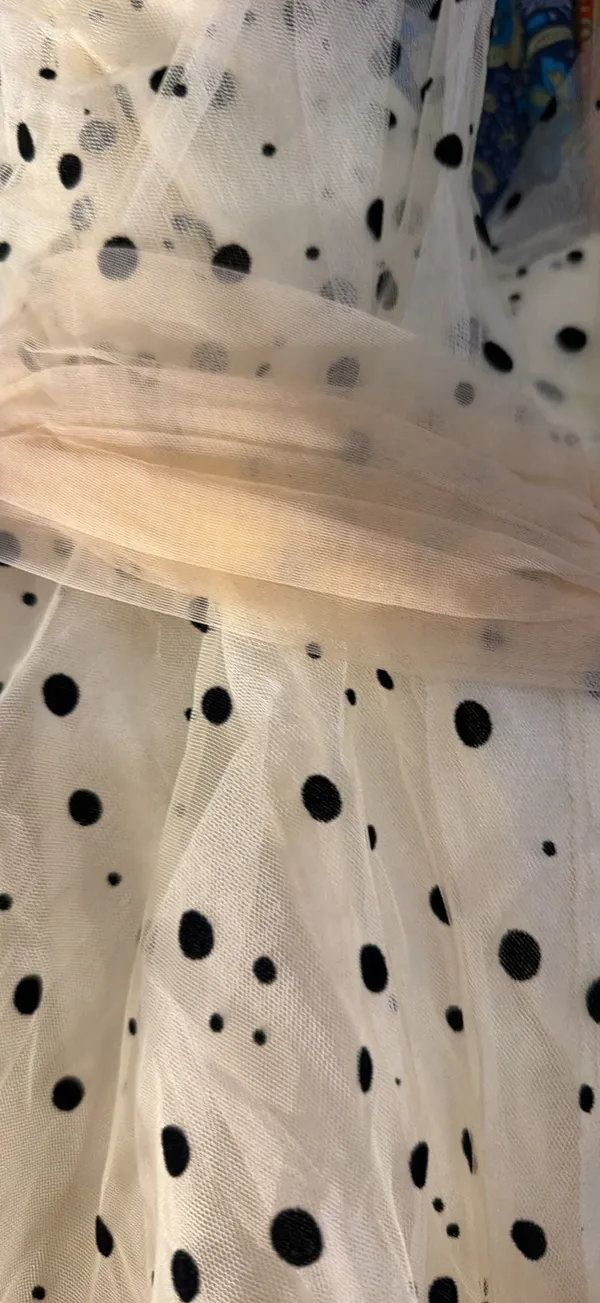 strapless tulle mini dress featuring a cream or light beige mesh fabric adorned with classic black polka dots. It is designed with a heavily ruched, pleated sweetheart bodice, a defined cinched waistband, and a voluminous tiered ruffled skirt. - Image 7