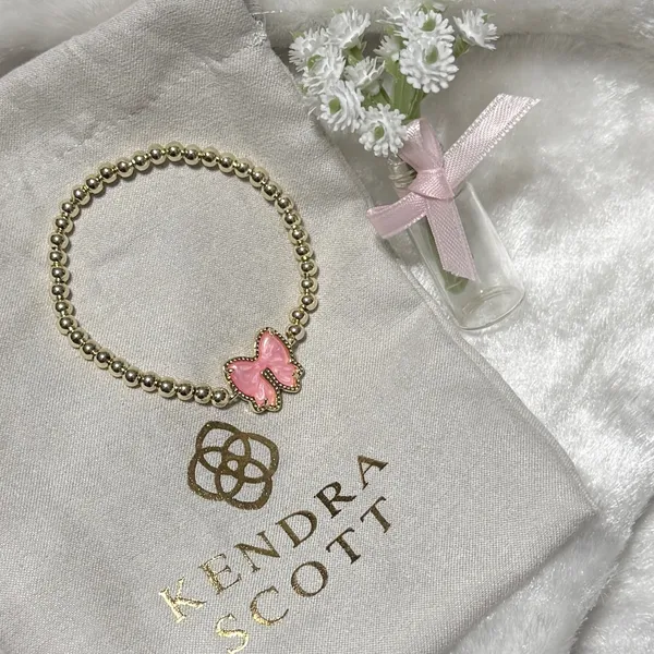 Kendra Scott Haley Bow Gold Stretch Bracelet featuring a custom-carved pink bow - Image 2