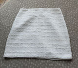 Chic white mini skirt with textured horizontal detailing. Slim, flattering silhouette. Easy to pair with tops or jackets for polished looks. Photo 0