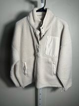 S107. WILO The Label, size Small, an ivory/cream cozy sherpa fleece pullover with snap placket, chest pocket, zip hand pockets, and adjustable hem. Photo 0