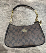 Elegant Coach shoulder bag in the classic brown and black Signature “C” canvas. Features black trim, gold-tone hardware, a zip-top closure, and a stylish black shoulder strap with decorative gold chain details. Compact yet roomy—perfect for everyday essentials or a chic night out. Photo 0